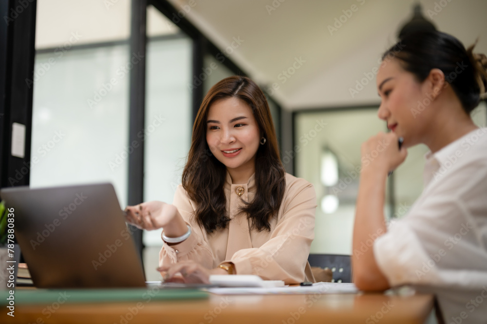 A confident businesswoman engages in a discussion with a colleague, leading a business meeting in a well-lit office space... A confident businesswoman engages in a discussion with a colleague, leading a business meeting in a well-lit office space...