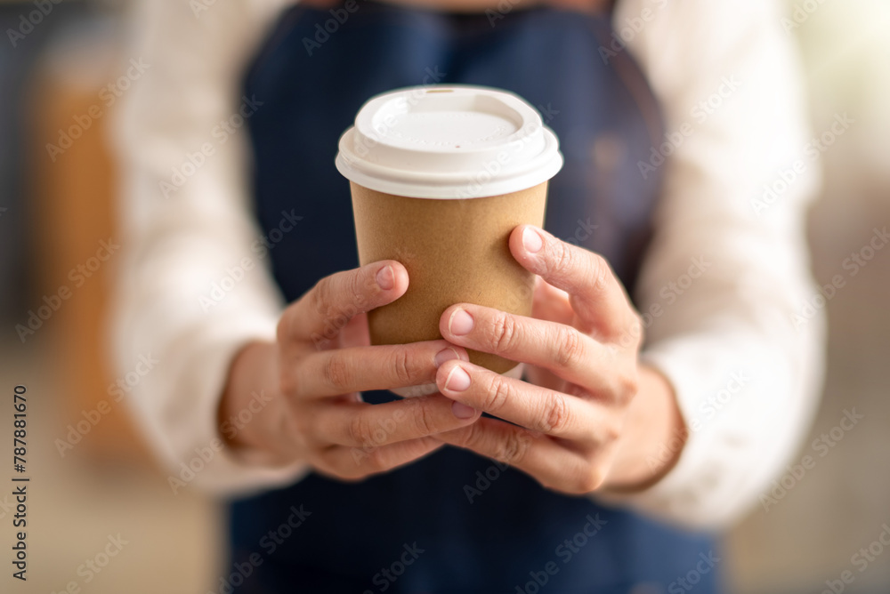 A close-up view of a person's hands gently holding a recyclable coffee cup, representing a moment of comfort and warmth. A close-up view of a person's hands gently holding a recyclable coffee cup, representing a moment of comfort and warmth.