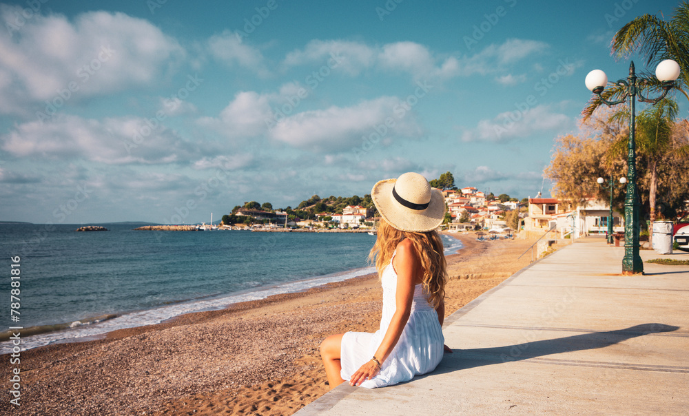 young woman sitting on the beach enjoying beautiful view