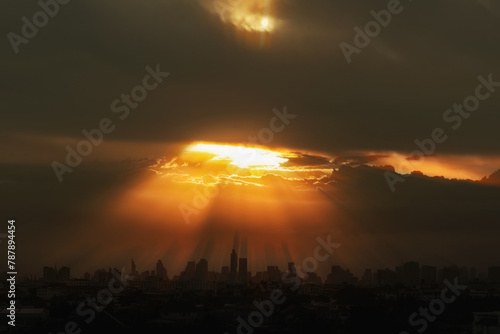 Background of sunlight orange with sky clouds in black silhouette city.