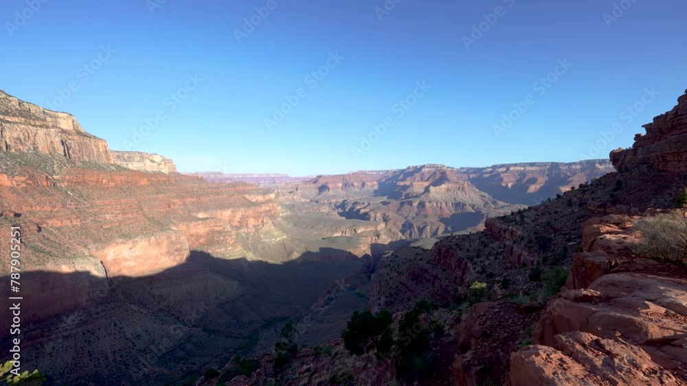 static shot of the Grand Canyon with morning light and shadows and a cloudless blue sky static shot of the Grand Canyon with morning light and shadows and a cloudless blue sky