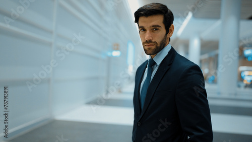 Portrait of smart business man looking at camera while standing with blurred background. Closeup of successful man staring at camera while wearing business suit. Business meeting or seminar. Exultant.