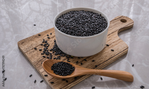 Asian black rice in a white dish on the cutting board. photo