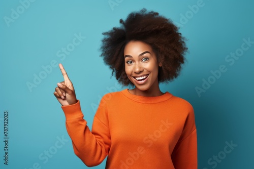 A woman with an afro pointing to the side