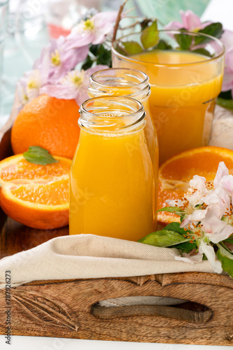 Orange juice in the glass bottles on a tray
