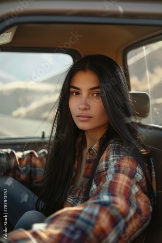 A woman sitting relaxed in the passenger seat of a car, looking out the window at passing scenery