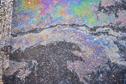 Fototapeta Naklejka Na Ścianę i Meble -  A car's oil and gas stains mark the surface of the parking asphalt