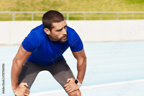 Fatigue, fitness and running with sports man in stadium venue for competition or performance. Exercise, tired and training with athlete or runner in recovery from track and field marathon or race © peopleimages.com