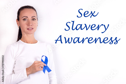 Sex slavery concept: a girl in bright clothes with a blue ribbon in her hand, as a symbol of awareness. photo