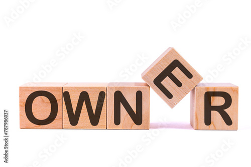 Word OWNER is made of wooden building blocks lying on the table and on a light background. Concept. photo