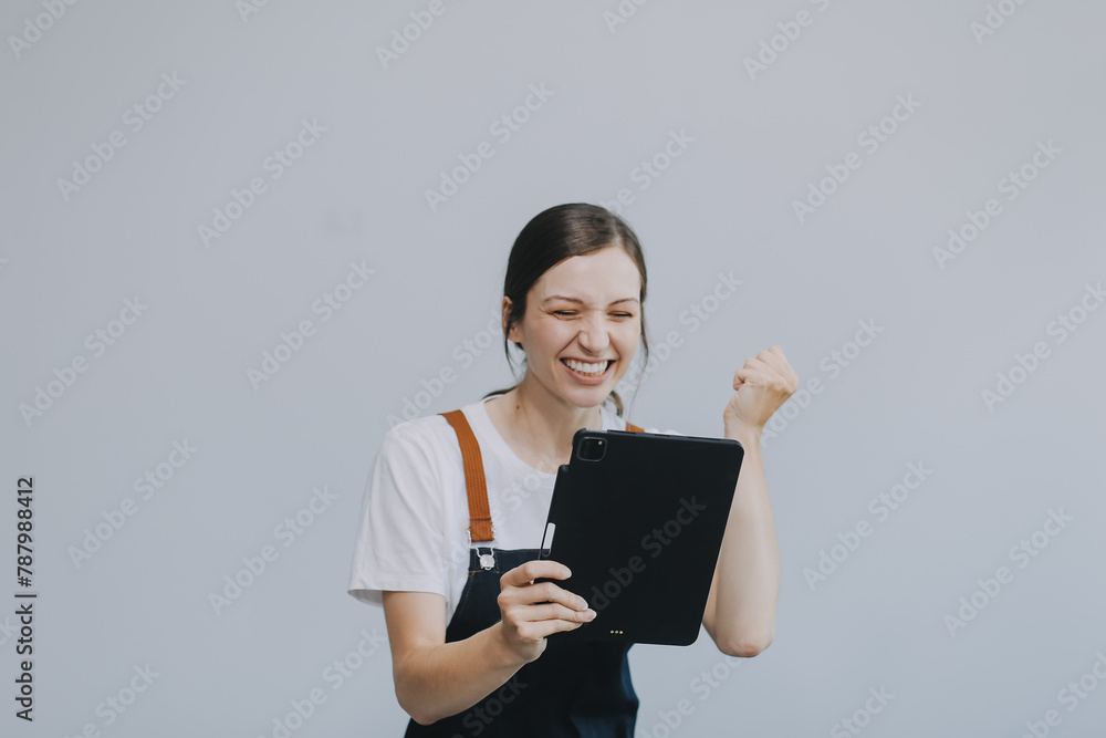 .Cheerful beautiful Asian woman wearing jeans overalls with excited doing winner gesture with arms raised isolated on white background. .Cheerful beautiful Asian woman wearing jeans overalls with excited doing winner gesture with arms raised isolated on white background.