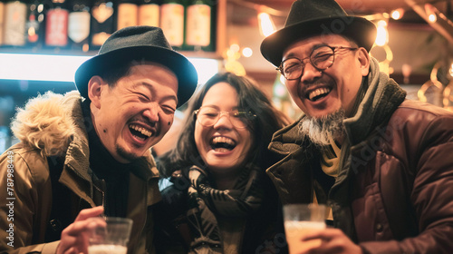 Tres amigos asiáticos de pie sonriendo y disfrutando con una bebida en la mano. Dos hombre y una mujer sonrientes celebrando una fiesta al aire libre.