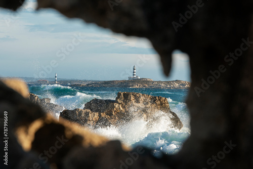 View of Faro de En Pou through rocks, Isla de los Puercos, Las Salinas Natural Park, Ibiza, Balearic Islands, Spain photo