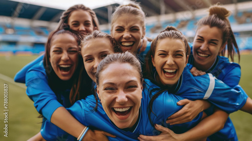 Happy women's soccer team celebrating winning the match on playing field.