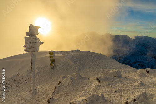 Guide post on Volovec peak at cold and cloudy winter evening. photo