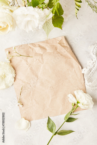 Natural beige mock up among white flowers. Aesthetic floral background for invitation, text, wishing, postcard flat lay