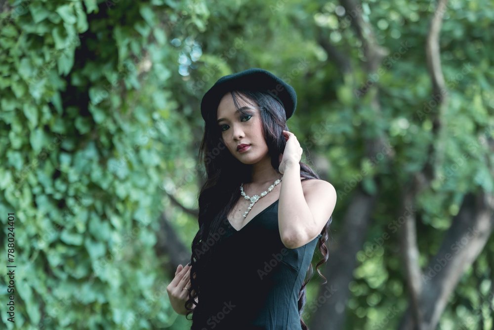 Young Asian woman in gothic attire posing in a lush forest setting Young Asian woman in gothic attire posing in a lush forest setting