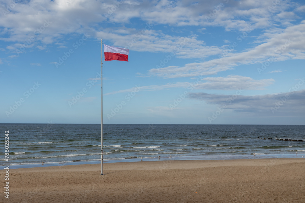 Polskie barwy narodowe, Polska flaga  na tle nieba nad morzem. Bałtyk Kołobrzeg Zachodniopomorskie  - obrazy, fototapety, plakaty 
