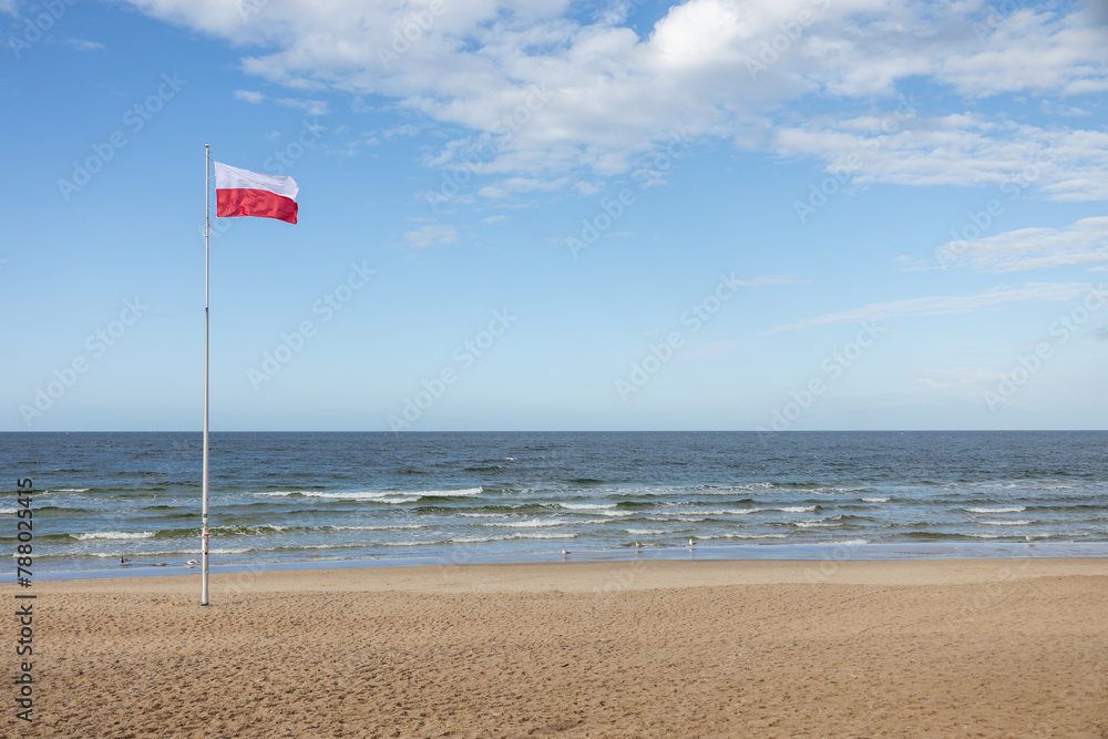 Polskie barwy narodowe, Polska flaga  na tle nieba nad morzem. Bałtyk Kołobrzeg Zachodniopomorskie  - obrazy, fototapety, plakaty 