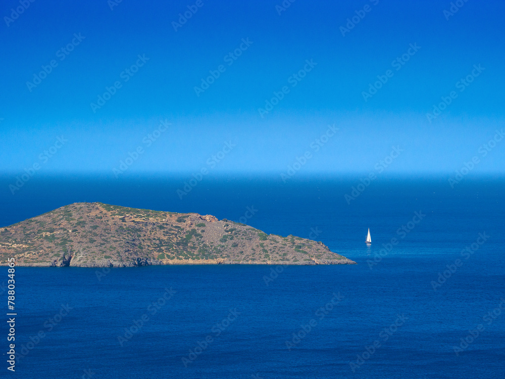 Deserted island in a blue sea (Elounda, Crete, Greece)