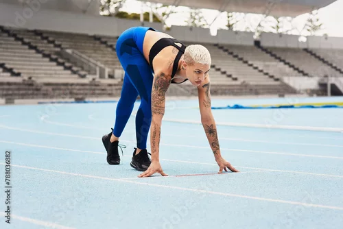 Obraz Woman, runner and start for track, exercise and warm up in stadium or field for fitness. Female athlete, training and sports in outdoor for wellness, performance and strong in cardio, body and mind