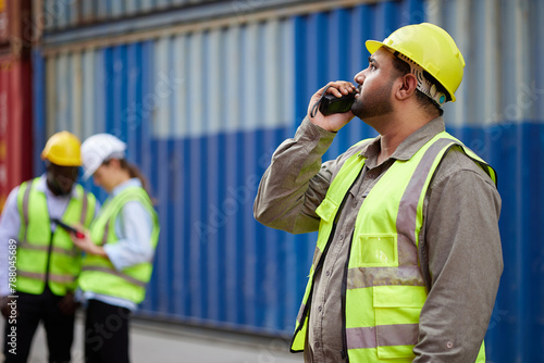 worker or engineer using walkie talkie and talking about work in containers warehouse storage