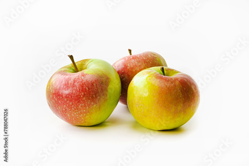Three red-green ripe apples on a white isolated background