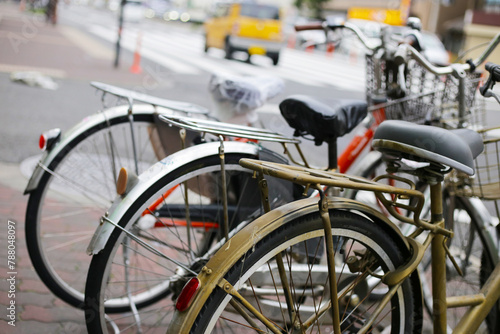 A group of bicycles lined up in a row on the sidewalk.