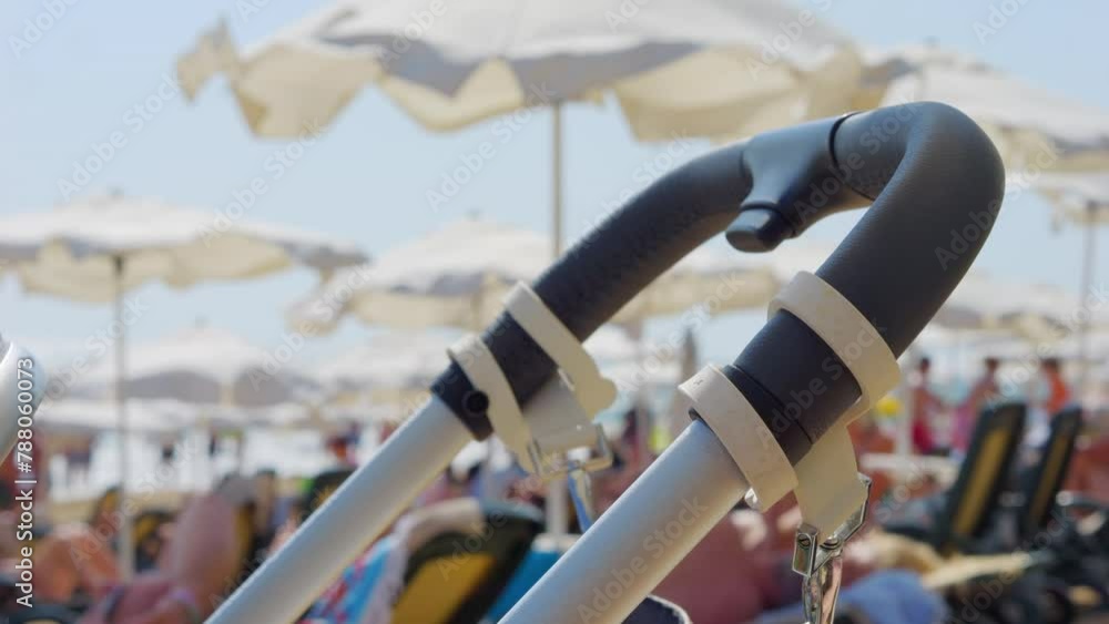 Baby stroller on beach with umbrellas in the background in 4k slow motion 120fps Baby stroller on beach with umbrellas in the background in 4k slow motion 120fps