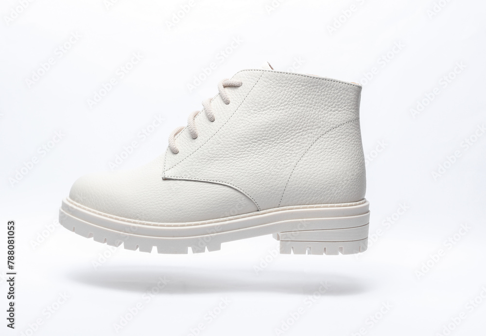 Floating white leather women's boot on a white background. Minimalism fashion still life Floating white leather women's boot on a white background. Minimalism fashion still life