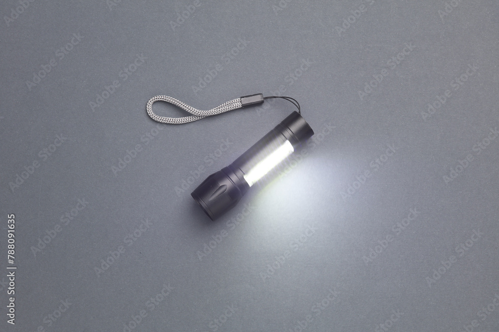 Pocket flashlight on dark gray background. Pocket flashlight on dark gray background.