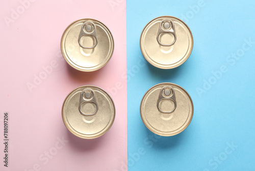 Cans with canned food on pink blue pastel background. Top view. Flat lay