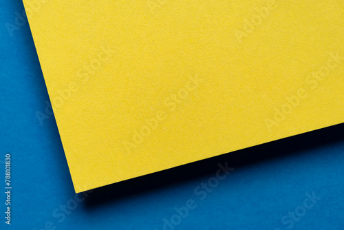 重なる黄色と青色の画用紙の背景