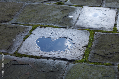 Puddle forming a heart on a stone tile
