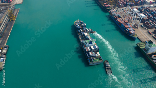 Aerial top view over international containers cargo ship at industrial import-export port prepare to load containers with big container loader ship vessel. global transportation and logistic business.