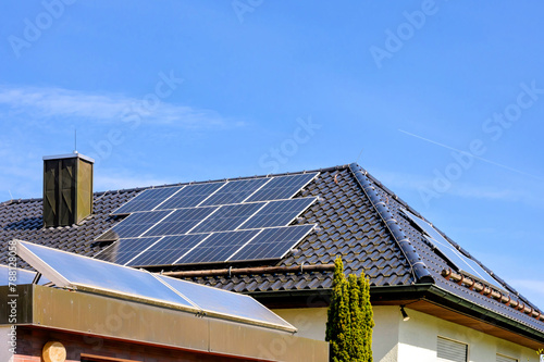 Modernes Wohnhaus und Garage mit Solaranlagen zur umweltfreundlichen Strom- und Warmwassererzeugung photo