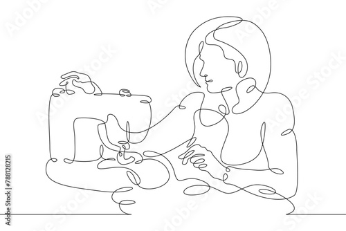 One continuous line.The fashion designer sews a dress. Seamstress works with sewing machine .Fashion designer, dressmaker, seamstress, sewing workshop or courses, tailoring concept.Working in atelier.