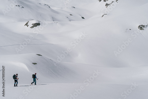 Tableau sur toile Athletes doing backcountry ski with a landscape of snowy mountains on a sunny day