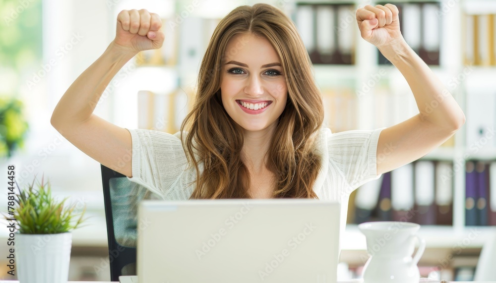 Triumphant young businesswoman celebrates success in front of laptop with arms raised Triumphant young businesswoman celebrates success in front of laptop with arms raised