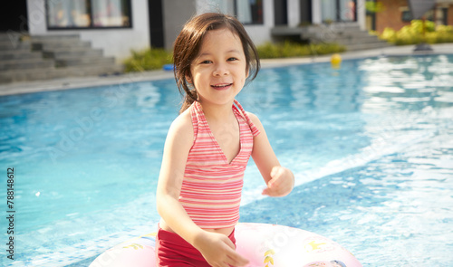 Cheerful child with float in pool