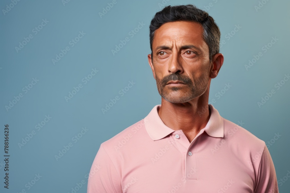 Portrait of a tender indian man in his 40s wearing a breathable golf polo isolated in pastel or soft colors background Portrait of a tender indian man in his 40s wearing a breathable golf polo isolated in pastel or soft colors background