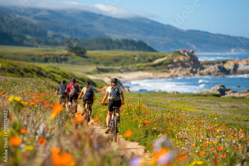 Group of travelers enjoying a scenic bike ride along a coastal path, surrounded by vibrant wildflowers and sea views