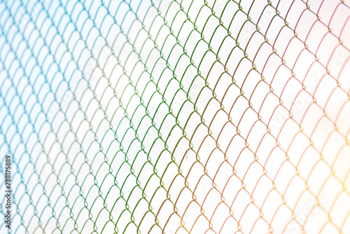 Mesh fence or metal grid at sunset. Steel grating fence made with wire on blue sky background. © Baurzhan I