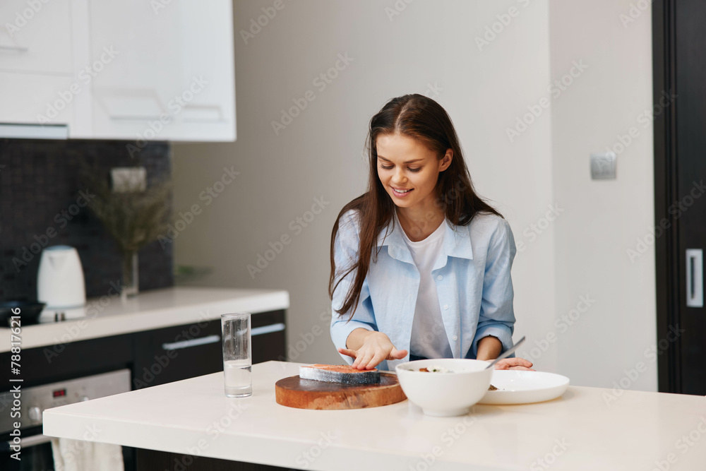 Attractive young woman cooking healthy breakfast in a stylish contemporary kitchen at home royaltyfree stock photo