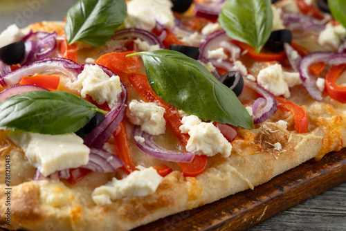 Traditional Roman pinsa with feta cheese, peppers and black olives.