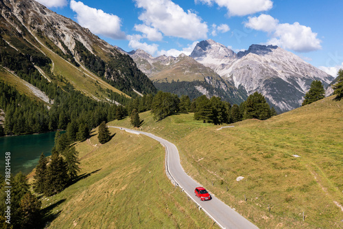 Car driving on the Albula mountain pass road in the alps in Canton Graubunden in Switzerland on a sunny summer day