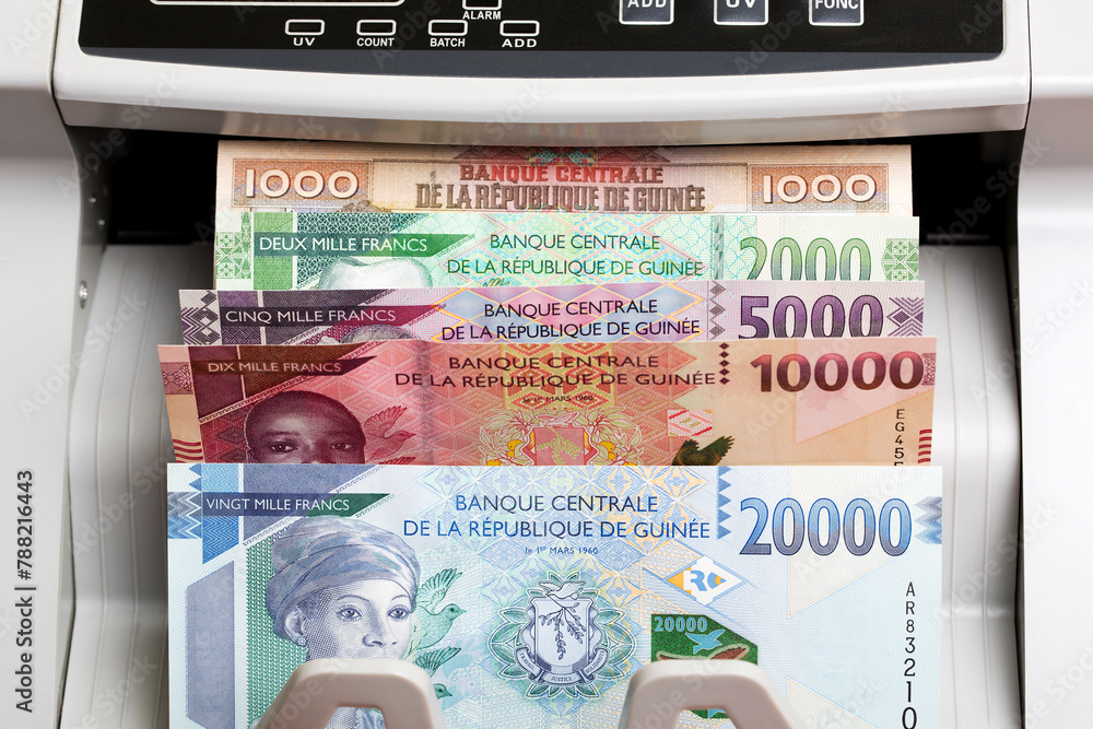 Guinean franc in a counting machine - obrazy, fototapety, plakaty 