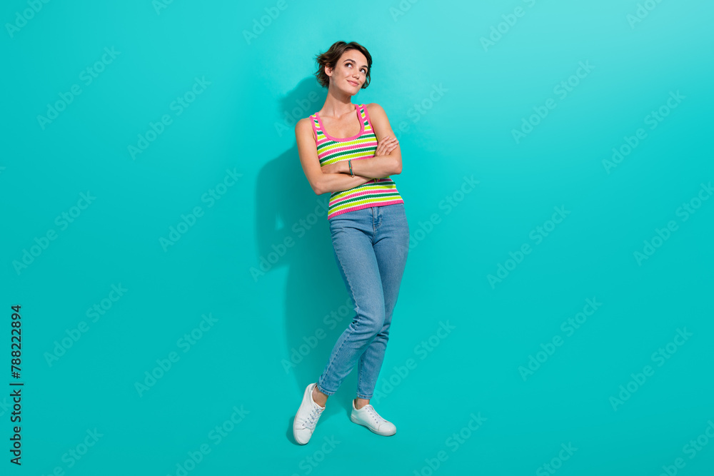 Full body photo of minded stunning lady folded hands look empty space fantasize isolated on teal color background Full body photo of minded stunning lady folded hands look empty space fantasize isolated on teal color background