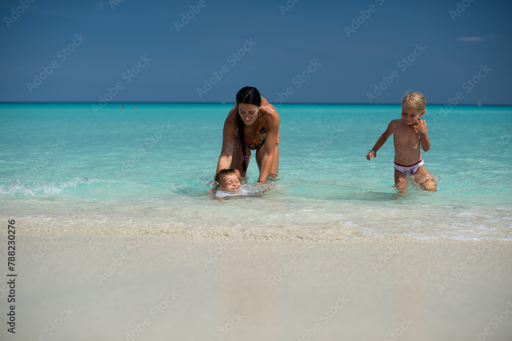 mom with children, playing with kid, family on the beach, swimming in the ocean, vacations in warm countries, Caribbean sea, Atlantic ocean, Cuba, childhood, parents, son