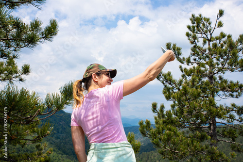 Tourist girl taking selfie with smartphone while Hiking in nature in the mountains © ArtmediaworX